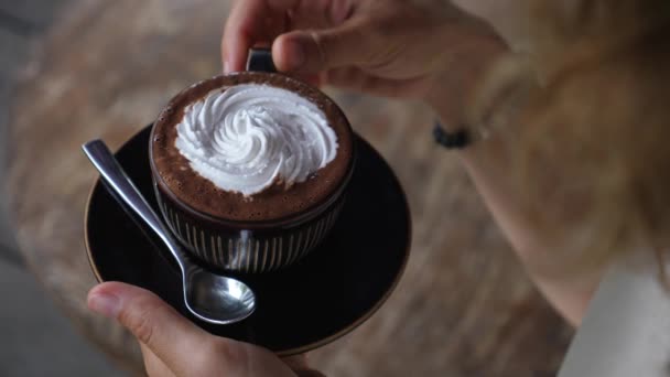 Handen nemen van een kopje melkvrije cappuccino met room op de top. — Stockvideo