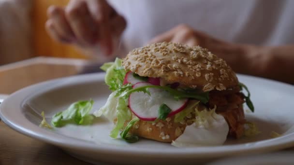 Close up de hambúrguer vegan com as mãos trabalhando no Ipad no fundo. Conceito de estilo de vida saudável. — Vídeo de Stock