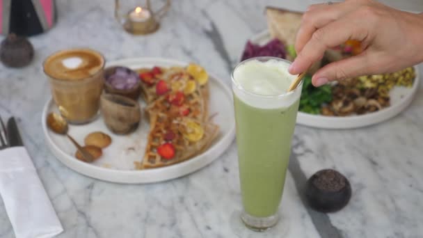 Concepto de comer limpio. Almuerzo vegano de gofres, tortilla, verduras, café con leche a base de plantas y café con leche con hielo matcha — Vídeos de Stock