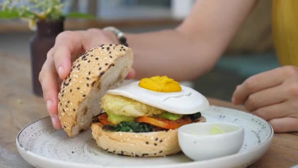 Orang menempatkan roti gluten gratis di atas burger berbasis tanaman. Street food dalam gaya vegan — Stok Video