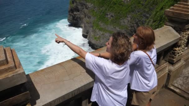 Hija adulta mostrando a su madre de mediana edad el océano desde el muelle de observación. Viajar con tus padres — Vídeo de stock