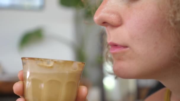 Großaufnahme des weiblichen Mundes, der mit großem Vergnügen einen Schluck pflanzlichen Kaffee-Latte nimmt. — Stockvideo