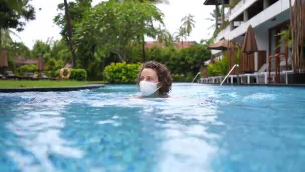 Reise während Covid-10-Pandemie in Schutzmaske in ihrem Vila-Pool. — Stockvideo