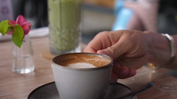 Kaukasiska tjejen njuter av en klunk varm vegansk cappuccino. Enkelt nöjesbegrepp. — Stockvideo