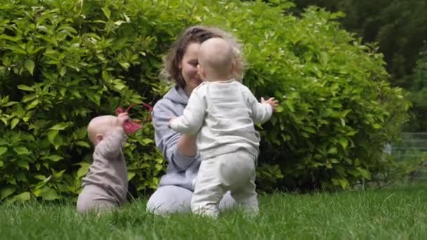 Mladá maminka fotografování její dítě dvojčata s smartphone v parku — Stock video