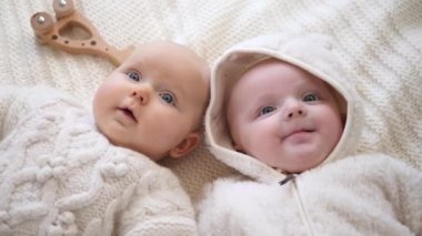 Birlikte yatan ikizler. Örgü süveter giyen Eko Tahta Oyuncaklarla oynayan Bebek Kızlar. 