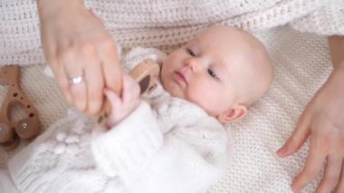 Bebek ve annesi rahat örgü kazaklar içinde Tahta oyuncaklarla birlikte oynuyorlar