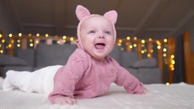 Yerde yatan şık örülü süveter giyen mutlu bebek kız. Çocukluk. Bebek..