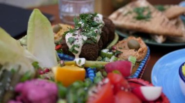 Orta doğulu sağlıklı vejetaryen meze tabağı falafel, humus, turşu, baba ghanoush ve çeşitli soslar. Vejetaryen usulü ezme