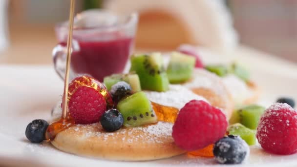 Verter Agave o jarabe de arce en panqueques veganos con bayas y frutas para el desayuno. — Vídeos de Stock