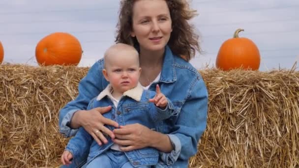 Portrét bělošské matky a dítěte v džínsech vypadá, jako by seděli na balíku sena a ukazovali na něco v dálce. Speciální pouto mezi mladou svobodnou matkou a dítětem