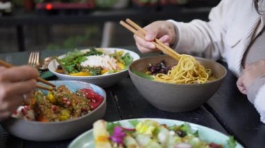 Doğu mutfağında öğle yemeği molası. Siyah ahşap masada renkli kaselerde servis edilen yemekler.. 