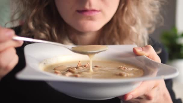 年轻女子吃洋葱南瓜奶油汤时穿的衣服. — 图库视频影像