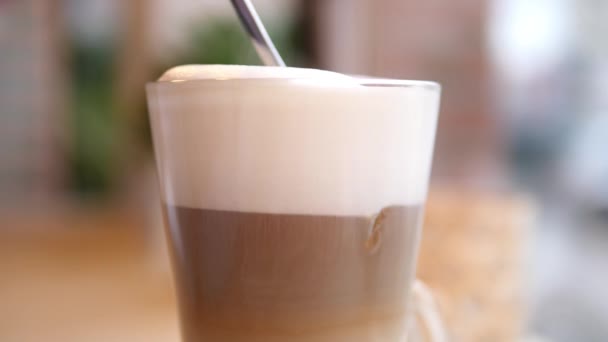 Schiuma spessa mescolante di Latte caldo del caffè con il cucchiaio in una tazza di vetro. — Video Stock