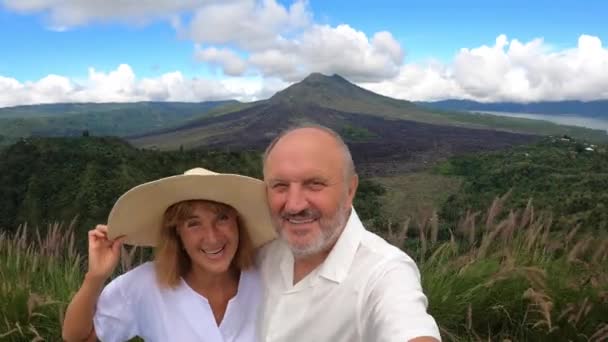 Romantiek na je pensioen. Middelbaar stel neemt een selfie op een achtergrond van een eilandlandschap — Stockvideo