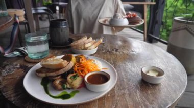 Sağlıklı lezzetli vejetaryen kahvaltısı. Tahta masada dondurmalı krep servis eden biri.