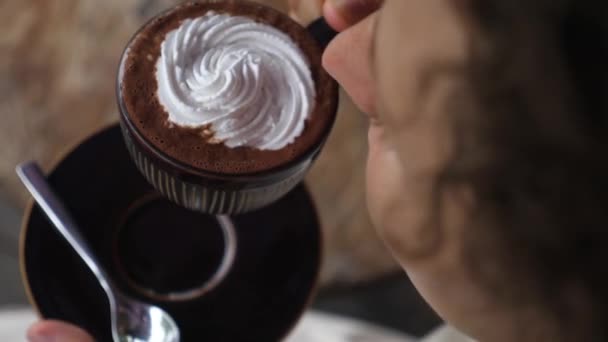 Horní pohled na samici, jak se napije veganské horké čokolády se smetanou navrchu — Stock video