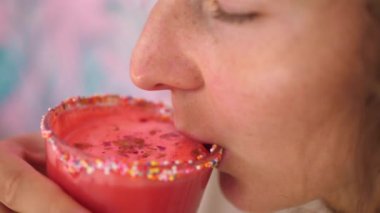 Pembe smoothie içen kadınlara yakın çekim. Cam parçalarıyla süslenmiş. Hipster konsepti 