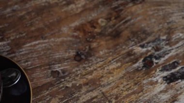 Elin, tahta bir masanın üzerinde krem şantili bitki esaslı bir fincan sıcak çikolata servis ediyor.