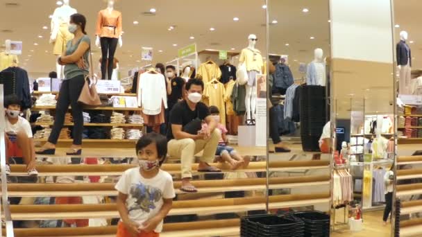 Un día ocupado en una tienda de ropa. Asiático significa con su hija sentada en las escaleras. Todos con máscaras faciales. Bali-enero-2020 — Vídeos de Stock