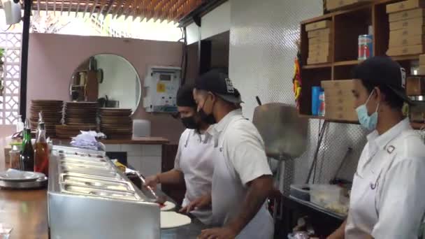 Boczne ujęcie kucharzy pizzy przygotowujących pizzę w otwartej kuchni. Bali-grudzień-2020 — Wideo stockowe