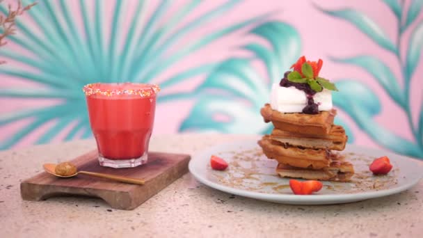 Postres veganos saludables equilibrados de gofres y batido a base de plantas. La pared rosa en la parte posterior — Vídeos de Stock