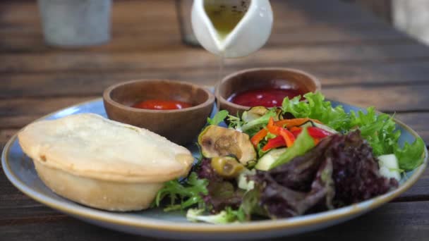 Веганський бранч з кіше, салату та соусів. Ручна приправа наливає олію на салат — стокове відео