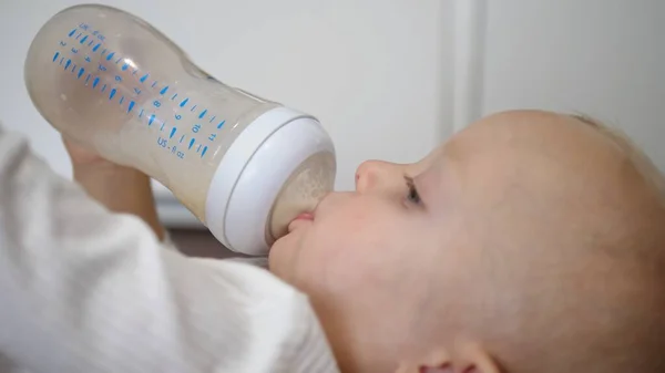 Caucasian baby drinking formula milk from a bottle