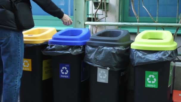 Человек, бросающий бумагу в мусорные баки. Концепция сегрегации отходов. Warsaw-Poland-2020 — стоковое видео