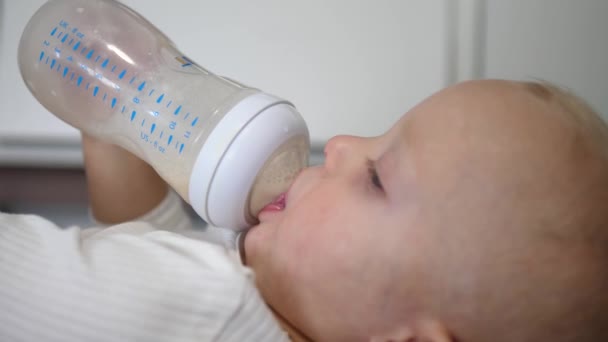 Кавказький дитячий напій формує молоко з пляшки. — стокове відео