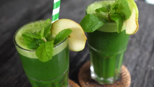 Detox and cleanse diet concept. Top view of green cold pressed juices served in glasses with mint leave and a paper straw — Stock Video