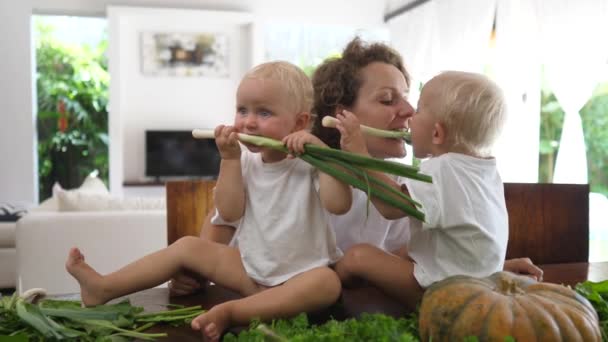 Jovem mãe com seus gêmeos do bebê cozinhar e jogar. Atividade de ligação divertida e educativa — Vídeo de Stock