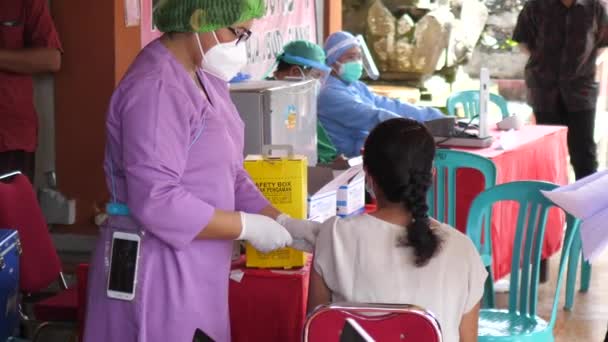 保健医療従事者は、 Bal.Indonesiaの保健センターでCovid-19ワクチンのジャブを入手します。 -2021年3月 — ストック動画