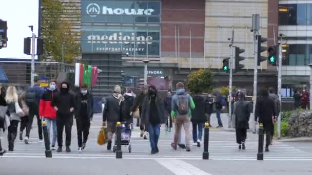 Społeczeństwo obserwuje covid-19 środki zapobiegawcze w celu odwrócenia pandemii. Wszyscy ludzie na ruchliwej ulicy w maskach na przejściu zebry w centrum miasta. Warszawa-Polska-2020 — Wideo stockowe