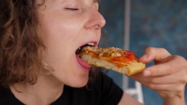 Vejetaryen pizzayı ısıran genç aç kadın. Yakın çekim..