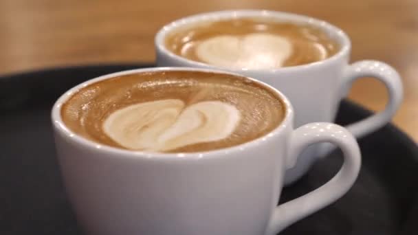 Lähikuva kahdesta kahvikupista kookosmaidolla. — kuvapankkivideo