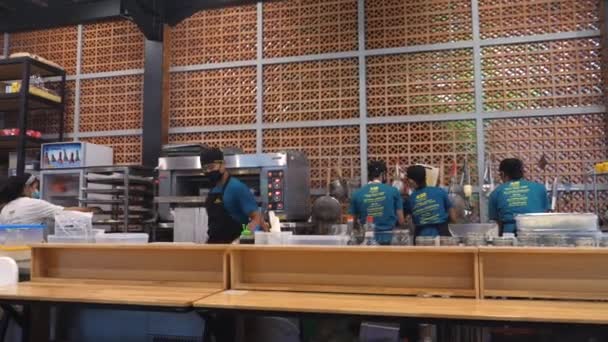 Ludzie w mundurach i maskach pracujących w otwartej kuchni w restauracji. Bali-grudzień-2020 — Wideo stockowe