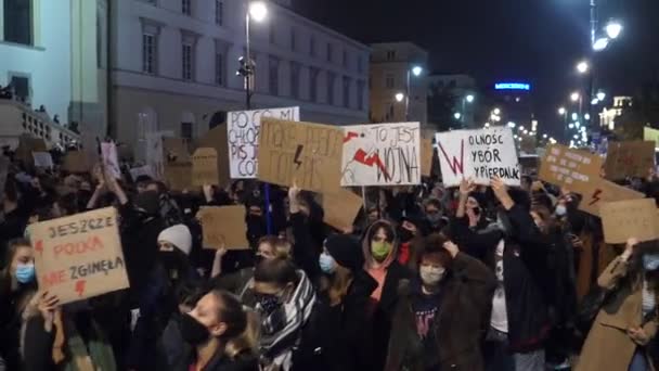 Lengyelország Abortusz-ellenes tüntetések a városban. Az aktivisták maszkot viselnek, tüntető jelekkel menetelnek. Varsó, Lengyelország, 2020. október 28. — Stock videók