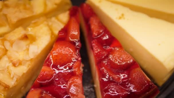 Close up de fatias de bolo de queijo fresco com frutas e bagas. Padaria exibição de sobremesa tentadora — Vídeo de Stock