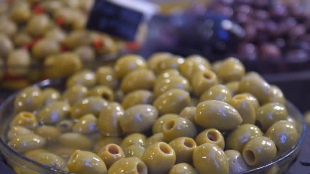 Espositore in vetro di olive ripiene e marinate assortite in negozio. Sano spuntino al supermercato senza confezione — Video Stock