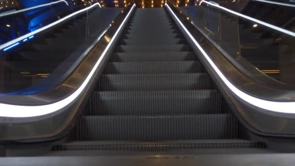 Close up de escadas em movimento ascendente com luzes brancas nas laterais do centro comercial e de negócios, sem pessoas ao redor — Vídeo de Stock