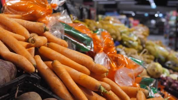 Zakupy jedzenia w dużym sklepie. Wyświetlacz sklepu spożywczego ze świeżymi zapakowanymi i opakowanymi darmowymi warzywami sprzedawanymi wagowo — Wideo stockowe