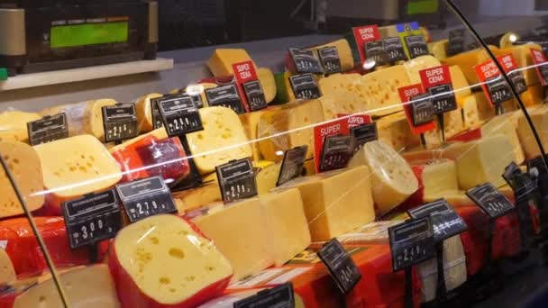 Contatore prodotti lattiero-caseari nel supermercato. Finestra di vetro con varietà di formaggio in offerta a prezzi ridotti — Video Stock