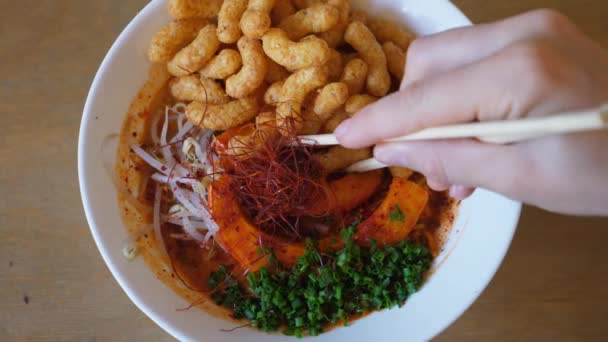 Top view of hand mixing vegan Japanese ramen in white bowl with chopsticks. Top food blog recipes of plant based oriental cuisine — Stock Video