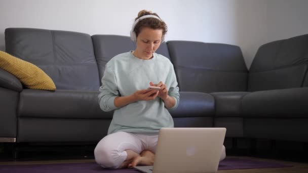 Digital yogi kvinna på matta välja online meditation klass från app hemma. Självisolering vid nedstängning av coronavirus — Stockvideo