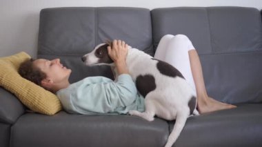 Coronavirus salgını sırasında evde köpeğiyle birlikte karantinada yatan genç mutlu kadın..