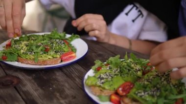 İki arkadaş kafe 'de avokado tostu ve limon suyu giyiyorlar. Vejetaryenler birlikte akşam yemeği yer. 