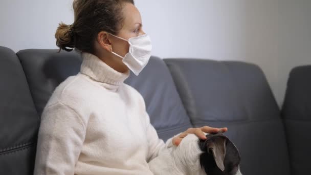 COVID-19 Pandemic Coronavirus Concept. Mujer con perro en cuarentena en casa aislamiento usando máscara protectora. — Vídeos de Stock