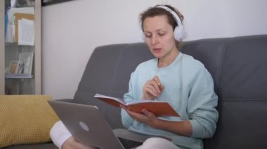 Kapalı devre 19 süresince sürekli kendini eğitme. Kendi kendini izole eden kadın kucağında bilgisayarla evdeki çevrimiçi eğitim platformundan uzak e-sınıfı alıyor 