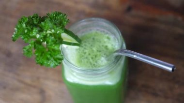 Soğuk baskılı meyve suyu arındırma. Sürdürülebilir metal bir pipetle yeşil meyve suyu kavanozunun üst görüntüsü. 